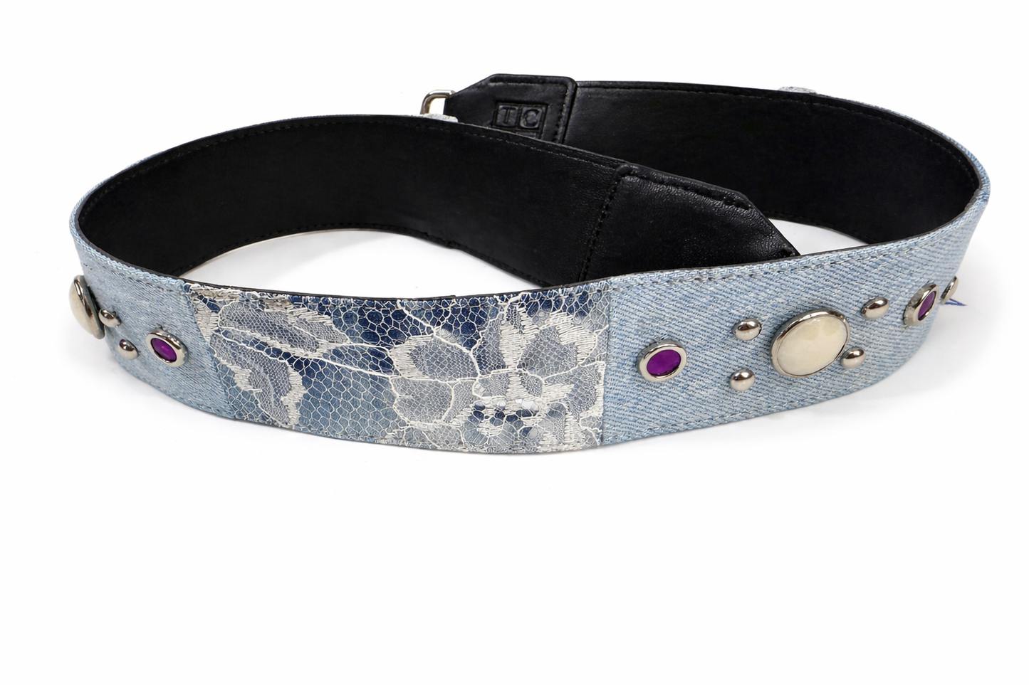 Denim belt with floral pattern and decorative studs on a white background