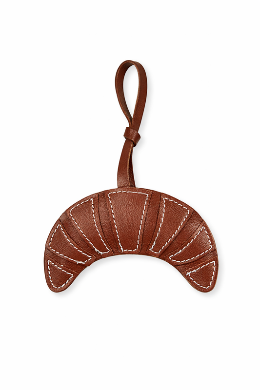 Brown leather crescent moon-shaped keychain on a white background