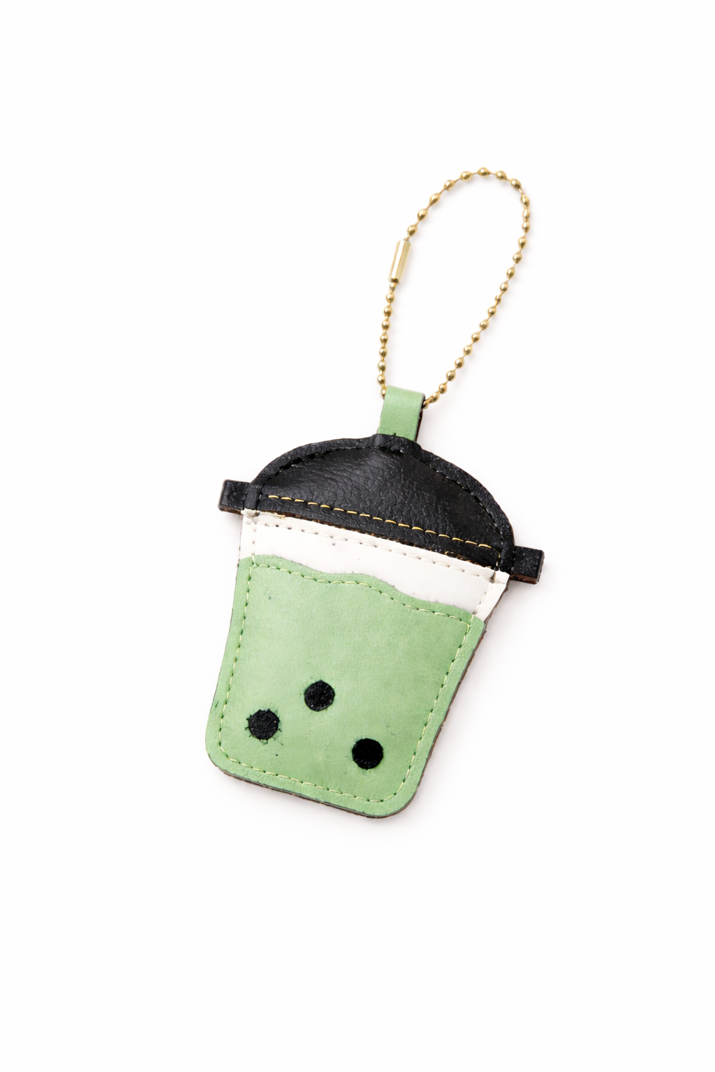 Green and black keychain resembling a cup with polka dots on a white background
