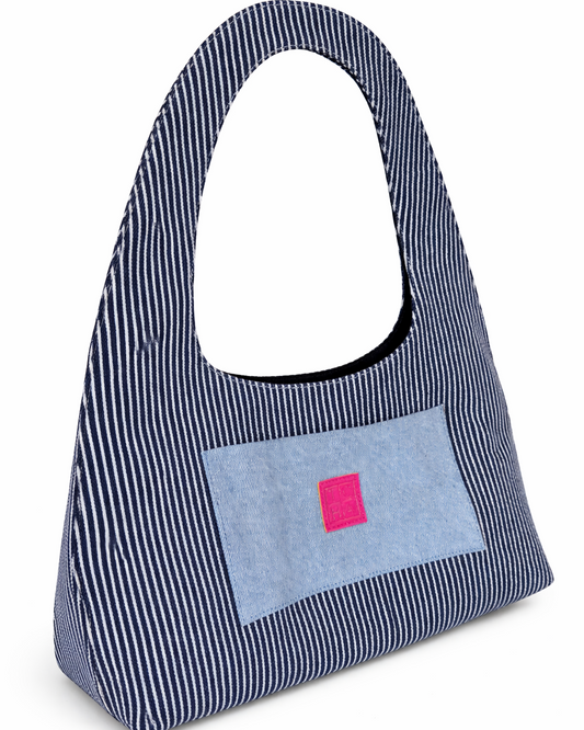 Blue striped handbag with a pink square patch on a white background