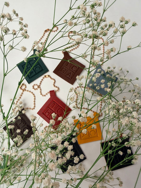 Color brand charms arranged among dried flowers on a white background